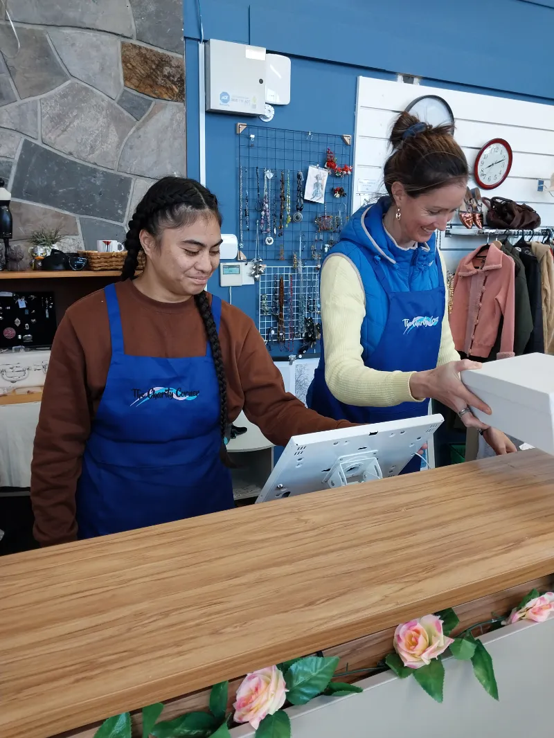 Two volunteers serving at the Charity Corner