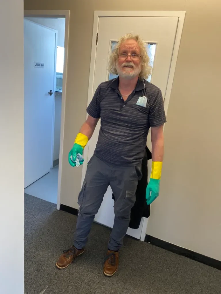 A ME Respite volunteer wearing rubber gloves for cleaning